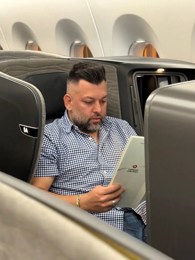 Renato lendo o cardápio da classe executiva da Turkish Airlines